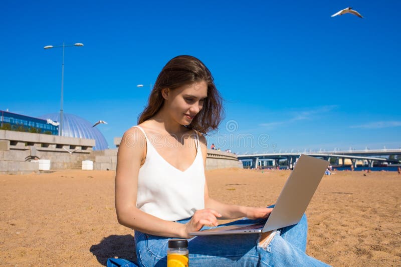 Schreibenartikel des hübschen frohen weiblichen Berufsverfassers auf netbook lizenzfreies stockbild
