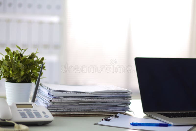 Schreibtisch mit einem Computer und einem Stapel Papieren
