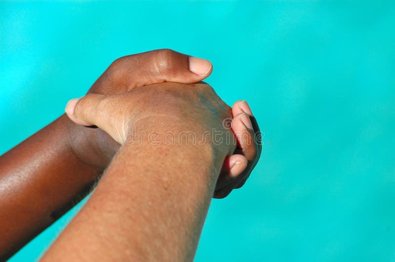 A black hand of an African American woman and a white hand of an caucasian woman shaking, helping and supporting each other. A black hand of an African American woman and a white hand of an caucasian woman shaking, helping and supporting each other