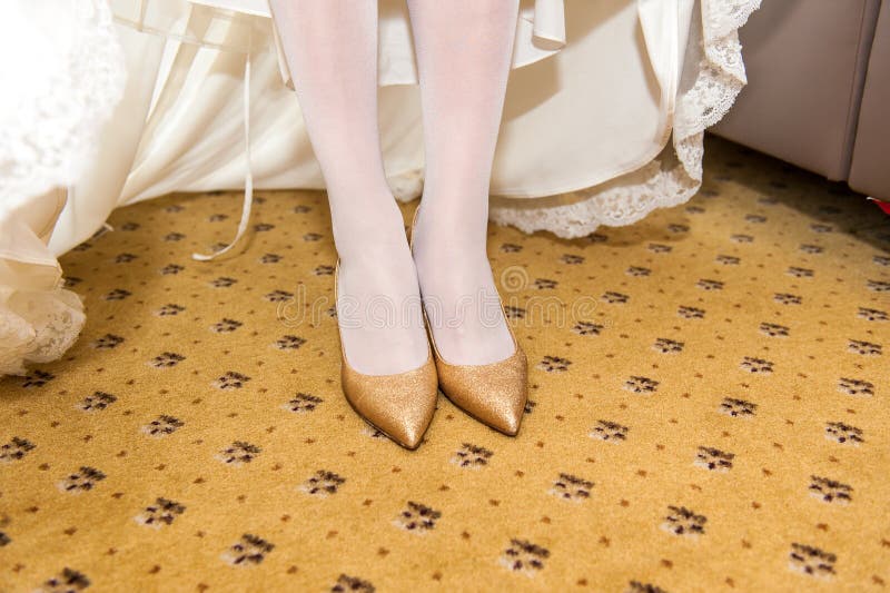 Schuhe der goldenen Heirat auf Brautfüßen lizenzfreie stockfotos Schuhe der goldenen Heirat auf Brautfüßen lizenzfreie stockfotos