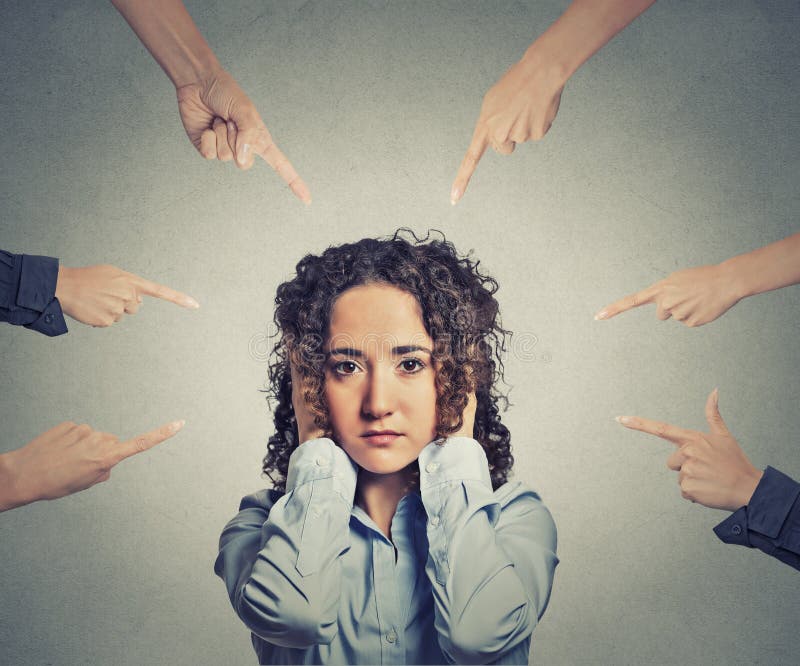 Concept of accusation of guilty businesswoman many fingers pointing at her. Portrait sad unhappy woman covering her ears doesn't want to hear grey office background. Human face expression. Concept of accusation of guilty businesswoman many fingers pointing at her. Portrait sad unhappy woman covering her ears doesn't want to hear grey office background. Human face expression