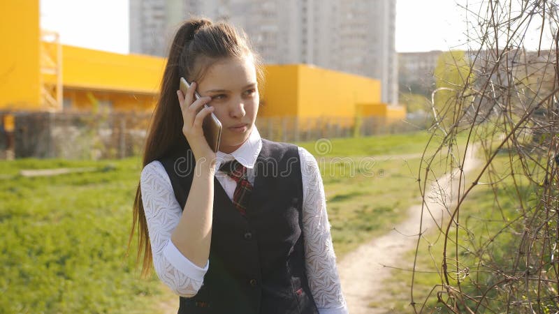 Schulm?dchen kommt von der Schule nach Hause M?dchenjugendlichgespr?che zu seiner Mutter am Telefon auf dem Heimweg