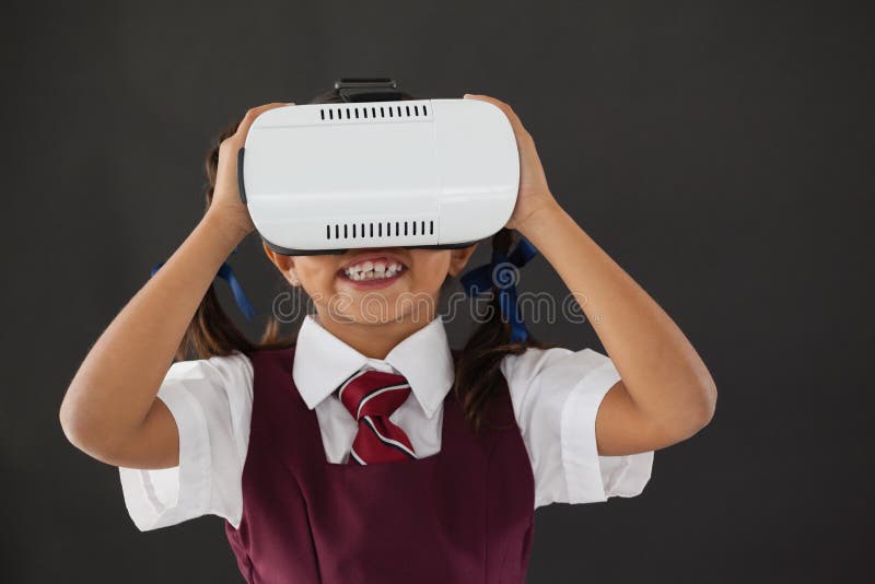 Schulmädchen, das Kopfhörer der virtuellen Realität gegen Tafel verwendet