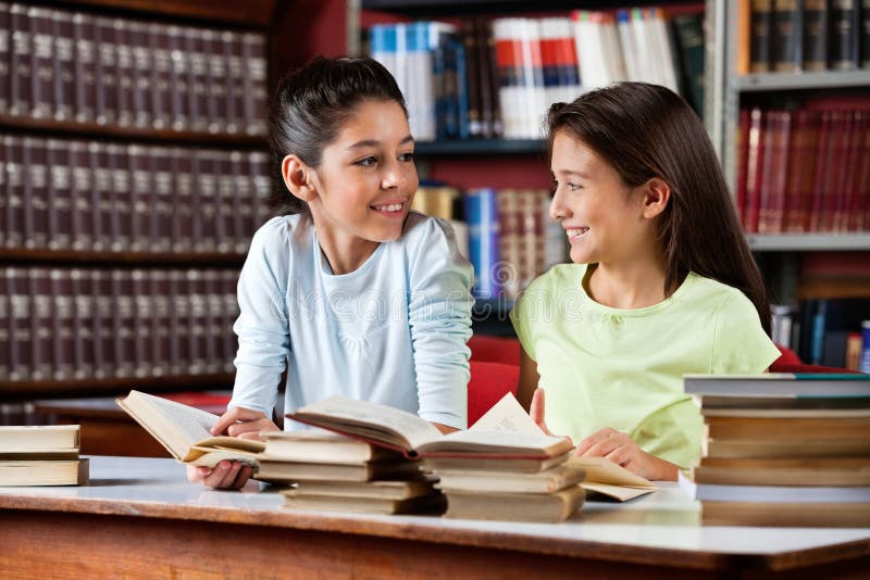 Schulmädchen, die einander beim Studieren betrachten stockbild Schulmädchen, die einander beim Studieren betrachten stockbild