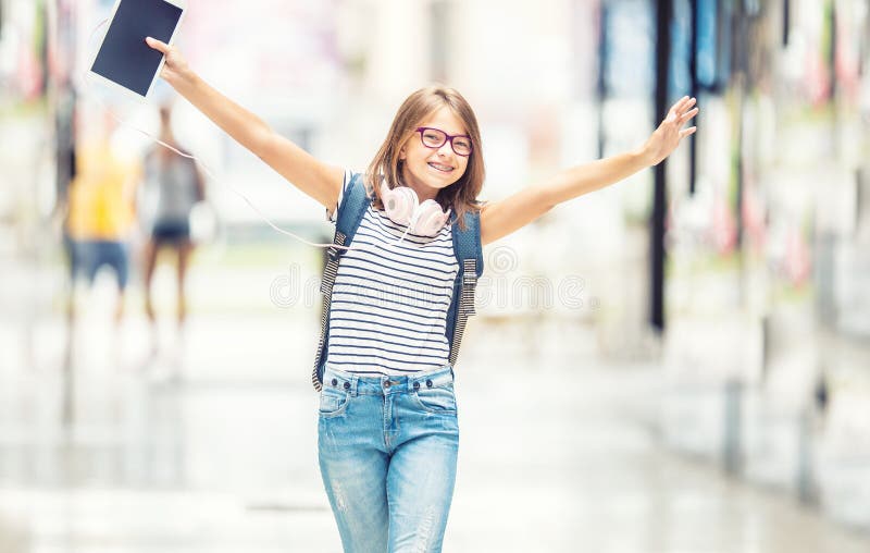Schulmädchen mit Tasche, Rucksack Porträt des modernen glücklichen jugendlich Schulmädchens mit Taschenrucksackkopfhörern und -ta
