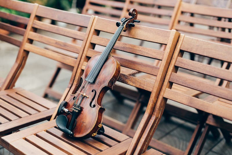 Schuss der Violine auf Holzstuhl, ohne Leute Klassische Musik und Kunstkonzept symphonie Horizontale Außenaufnahme lizenzfreies stockfoto Schuss der Violine auf Holzstuhl, ohne Leute Klassische Musik und Kunstkonzept symphonie Horizontale Außenaufnahme lizenzfreies stockfoto