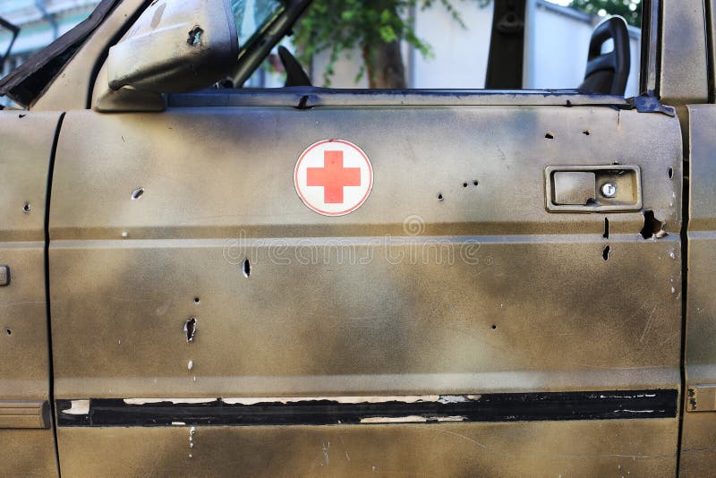 Schusskrankenwagen an der Szene von Feindseligkeiten Einschussl?cher im Metall lizenzfreies stockbild Schusskrankenwagen an der Szene von Feindseligkeiten Einschussl?cher im Metall lizenzfreies stockbild