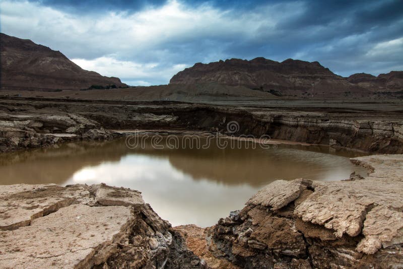 A Swallow hole at dead sea shore. during that winter morning the clouds create a beautiful view of the sky. A Swallow hole at dead sea shore. during that winter morning the clouds create a beautiful view of the sky.