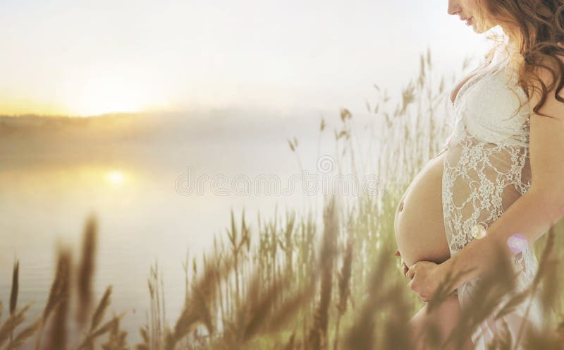 Schwangere Dame, die auf die frische Sommerwiese geht lizenzfreie stockbilder Schwangere Dame, die auf die frische Sommerwiese geht lizenzfreie stockbilder