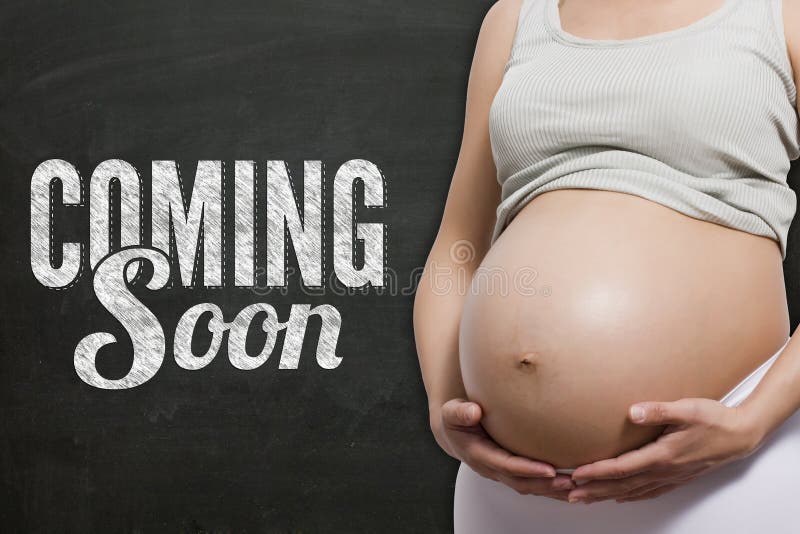 Pregnant woman in front a chalkboard with coming soon text. Pregnant woman in front a chalkboard with coming soon text