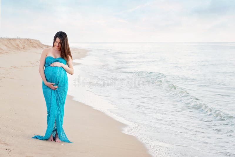 Schwangere Frau auf dem Strand stockfotografie Schwangere Frau auf dem Strand stockfotografie