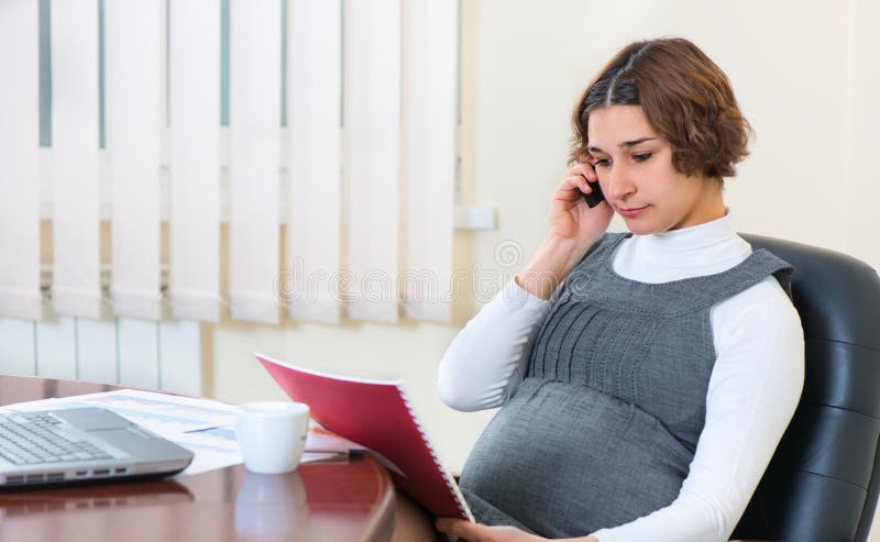 Schwangere Frau der Junge, die im Büro arbeitet stockfotos Schwangere Frau der Junge, die im Büro arbeitet stockfotos