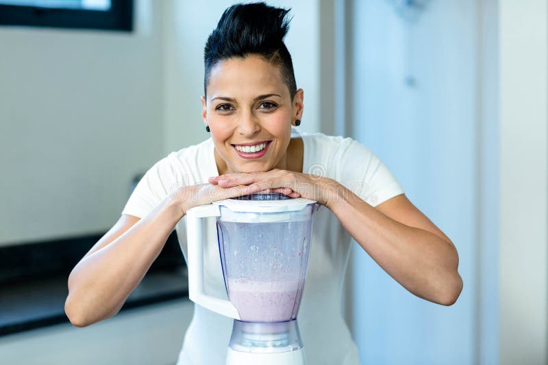 Pregnant woman leaning on blender in kitchen. Pregnant woman leaning on blender in kitchen