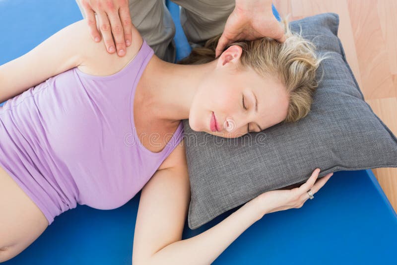 Schwangere Frau, die eine entspannende Massage hat stockfotografie Schwangere Frau, die eine entspannende Massage hat stockfotografie