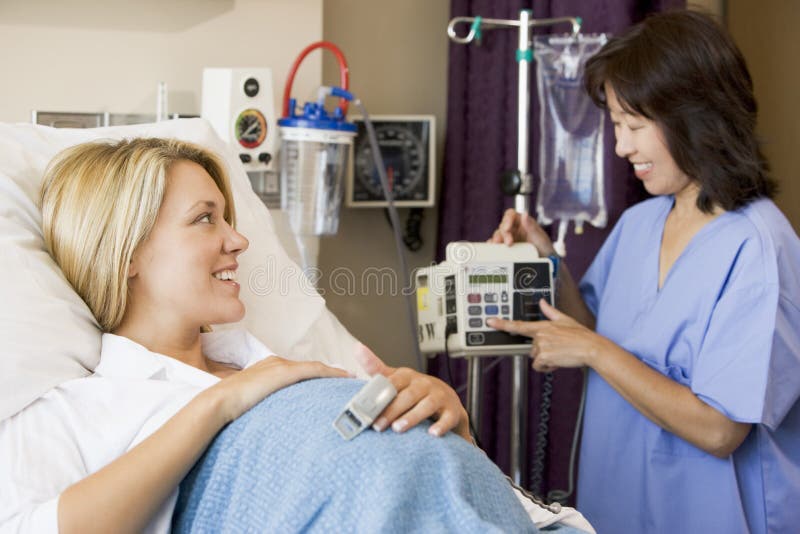 Schwangere Frau, die im Krankenhaus-Bett liegt lizenzfreie stockfotografie