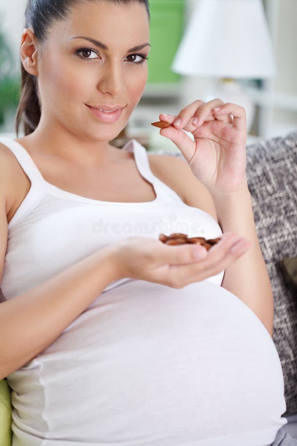 Schwangere Frau, die Mandel isst lizenzfreie stockfotos Schwangere Frau, die Mandel isst lizenzfreie stockfotos