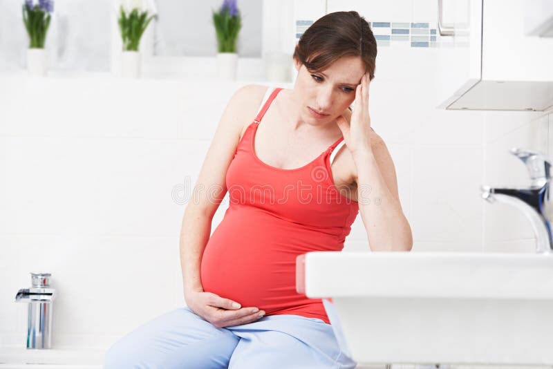 Schwangere Frau, die mit Schwangerschaftsübelkeit im Badezimmer leidet lizenzfreies stockbild Schwangere Frau, die mit Schwangerschaftsübelkeit im Badezimmer leidet lizenzfreies stockbild