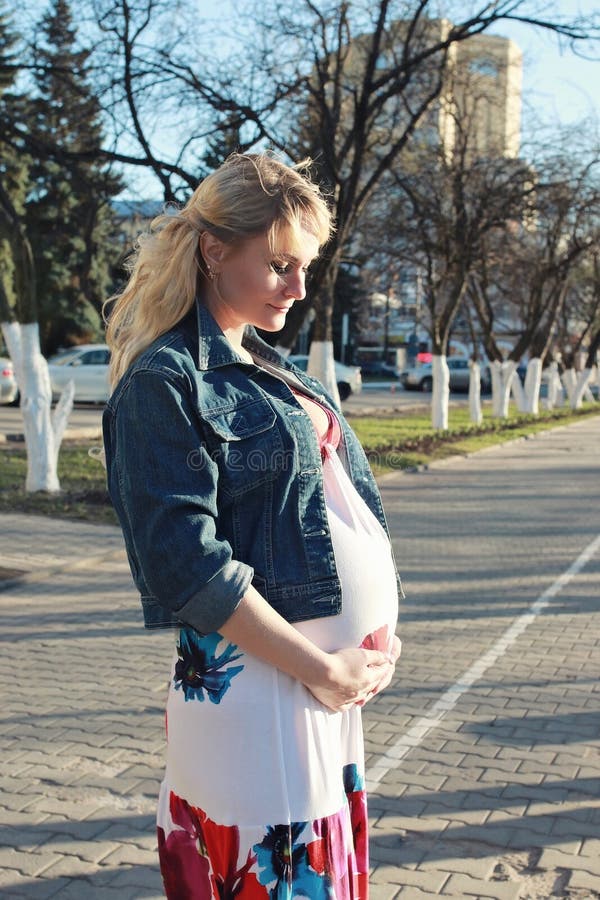 Schwangeres Mädchen geht um den Stadtpark im Frühjahr lizenzfreies stockfoto Schwangeres Mädchen geht um den Stadtpark im Frühjahr lizenzfreies stockfoto