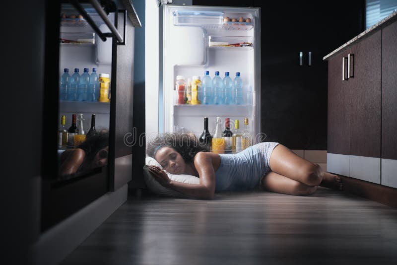 Schwarze Frau wach für die Hitzewelle, die im Kühlschrank schläft