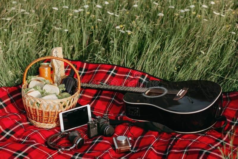Schwarze Gitarre und backet mit Sandwichen, Bier und Früchten auf rotem Picknick blancked Glücklicher Mann genießt an den Feierta stockfotos Schwarze Gitarre und backet mit Sandwichen, Bier und Früchten auf rotem Picknick blancked Glücklicher Mann genießt an den Feierta stockfotos