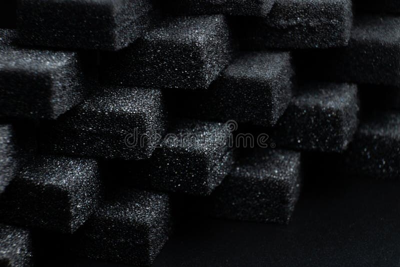 Schwarze Kuben mit flexiblen Schaumschwämmen, in einem Muster angeordnet. Makronähe im weichen Fokus. Abstrakter kubischer Hintergrund.