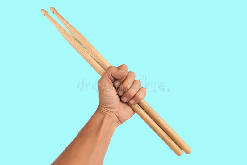 Black male hand holding wooden Drum sticks isolated on cyan background. High quality photo. Black male hand holding wooden Drum sticks isolated on cyan background. High quality photo