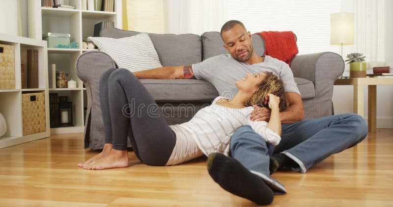 Schwarze Paare, die auf der Bodenunterhaltung sitzen stockfoto Schwarze Paare, die auf der Bodenunterhaltung sitzen stockfoto