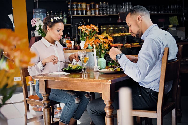 Schwarzer amerikanischer Mann und weibliches Lebensmittel des Essenstrengen vegetariers stockfoto Schwarzer amerikanischer Mann und weibliches Lebensmittel des Essenstrengen vegetariers stockfoto
