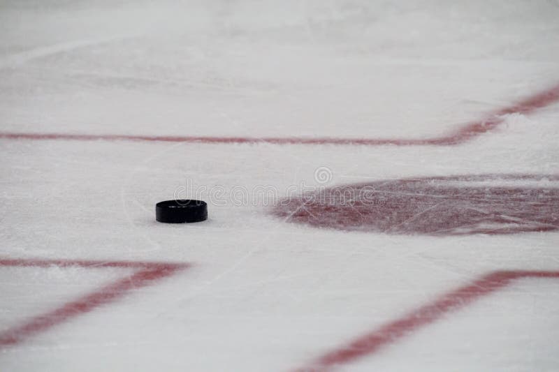 Black hockey puck on ice rink. Winter sport . Black hockey puck on ice rink. Winter sport .