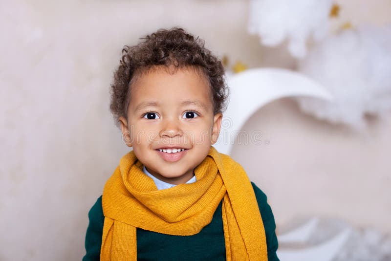 Schwarzer Jungenabschluß herauf Porträt Porträt eines netten lächelnden Jungen in einem gelben Schal das Baby l?chelt Wenig Afroa lizenzfreies stockfoto Schwarzer Jungenabschluß herauf Porträt Porträt eines netten lächelnden Jungen in einem gelben Schal das Baby l?chelt Wenig Afroa lizenzfreies stockfoto