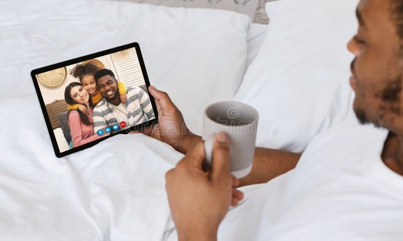 Schwarzer Mann, der Videokonferenz mit der Familie verwendet Tablette hat stockfotografie