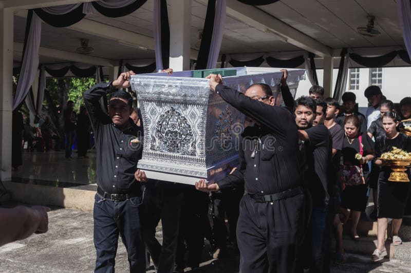 Phatthalung, Thailand- April 05, 2024: Man in black is helping to carry the coffin of the deceased into the crematorium for cremation. Phatthalung, Thailand- April 05, 2024: Man in black is helping to carry the coffin of the deceased into the crematorium for cremation