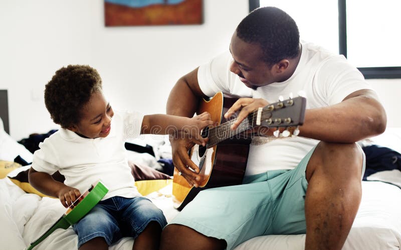 Schwarzer Vater genießen, Gitarre mit seinem Kindhappin zusammen zu spielen