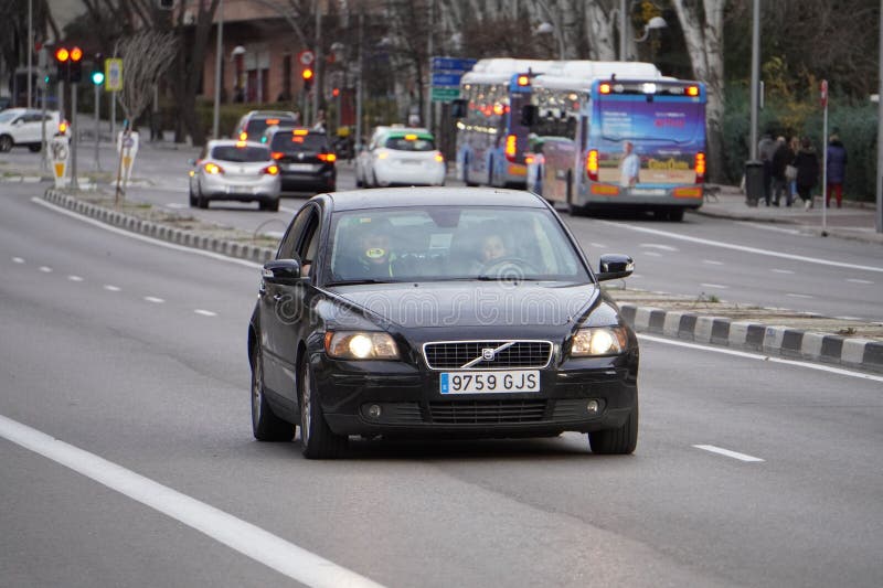 Schwarzer Volvo-Wagen mit gelbem Umweltzeichen c Fahren auf einer Straße von Madrid