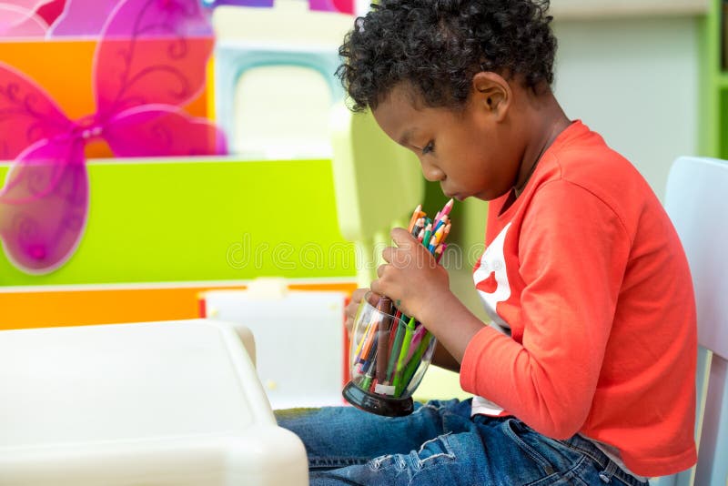 Schwarzes amerikanisches Kinderspiel mit Farbbleistift allein am Klassenzimmer in der Kindergartenvorschule, Ausbildungskonzept stockfotos Schwarzes amerikanisches Kinderspiel mit Farbbleistift allein am Klassenzimmer in der Kindergartenvorschule, Ausbildungskonzept stockfotos