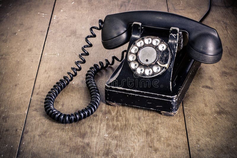 Old vintage rotary phone on a wood surface. Old vintage rotary phone on a wood surface.