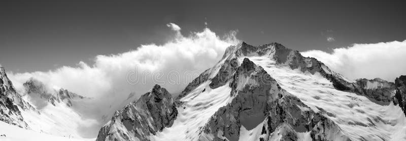 Black and white mountain panorama in clouds. Caucasus, region Dombay. View from the ski slope. Black and white mountain panorama in clouds. Caucasus, region Dombay. View from the ski slope.