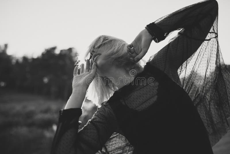 Schwarzweiss-Porträt der jungen Frau mit dem blonden Haar und Sonnenbrille draußen in der Natur beim Tanzen stockbilder Schwarzweiss-Porträt der jungen Frau mit dem blonden Haar und Sonnenbrille draußen in der Natur beim Tanzen stockbilder