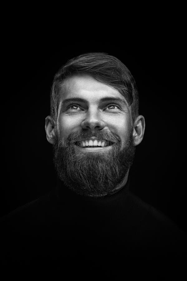 Schwarzweiss-Porträt des Lachens des jungen bärtigen Mannes lizenzfreies stockfoto