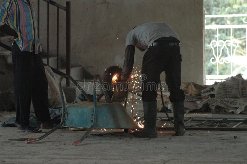 Schweißerschweißensschubkarre in Ghana lizenzfreies stockfoto Schweißerschweißensschubkarre in Ghana lizenzfreies stockfoto