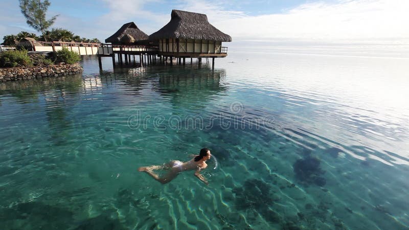 Schwimmen der jungen Frau in einer korallenroten Lagune
