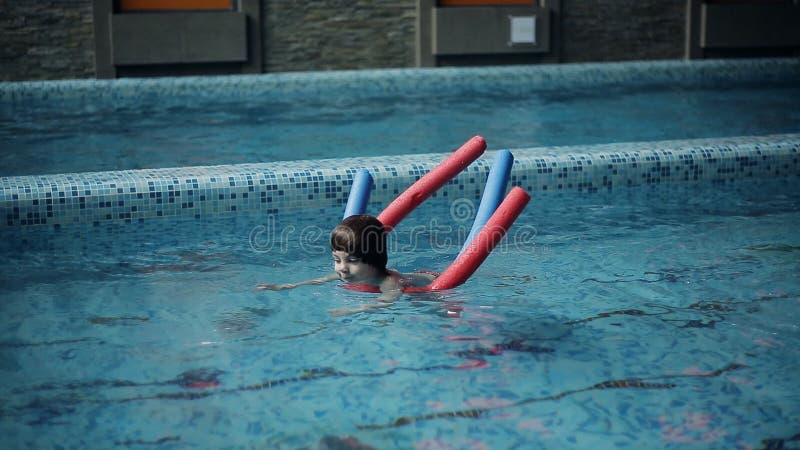 Schwimmen des kleinen Jungen im Pool in der Freizeitmitte