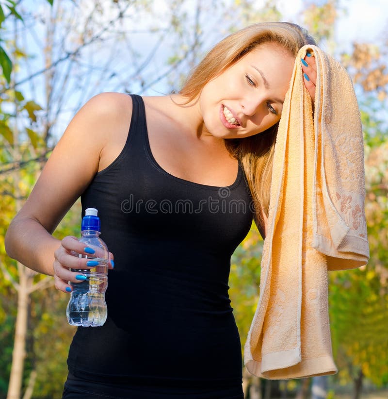 Schwitzender Frauenathlet, der sie abwischt stockfotografie Schwitzender Frauenathlet, der sie abwischt stockfotografie