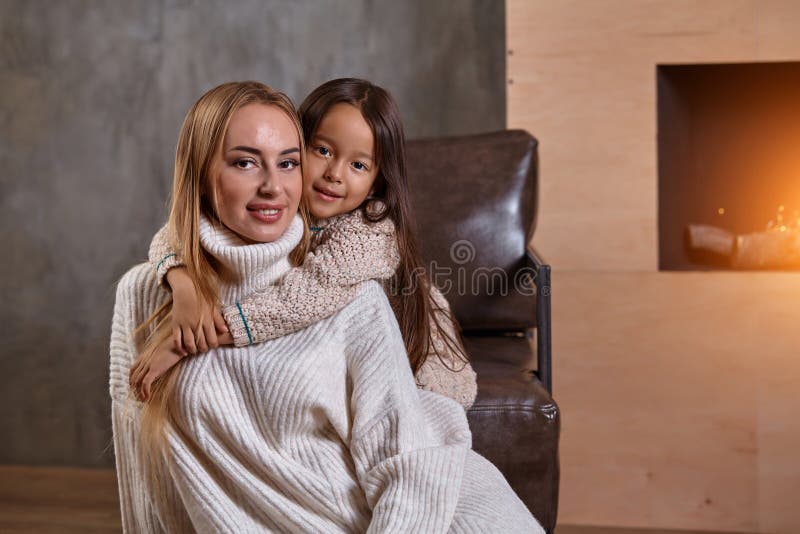 Schöne Mutterfrau in der weißen Strickjacke umarmt ihre kleine Tochter Nette spielerische Stimmung und Liebe innerhalb der Famili lizenzfreies stockbild Schöne Mutterfrau in der weißen Strickjacke umarmt ihre kleine Tochter Nette spielerische Stimmung und Liebe innerhalb der Famili lizenzfreies stockbild