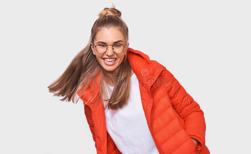 Schönes blondes Lachen der jungen Frau über etwas lustig, angekleidet im weißen T-Shirt und in der roten Jacke, tragender runder stockfotografie Schönes blondes Lachen der jungen Frau über etwas lustig, angekleidet im weißen T-Shirt und in der roten Jacke, tragender runder stockfotografie