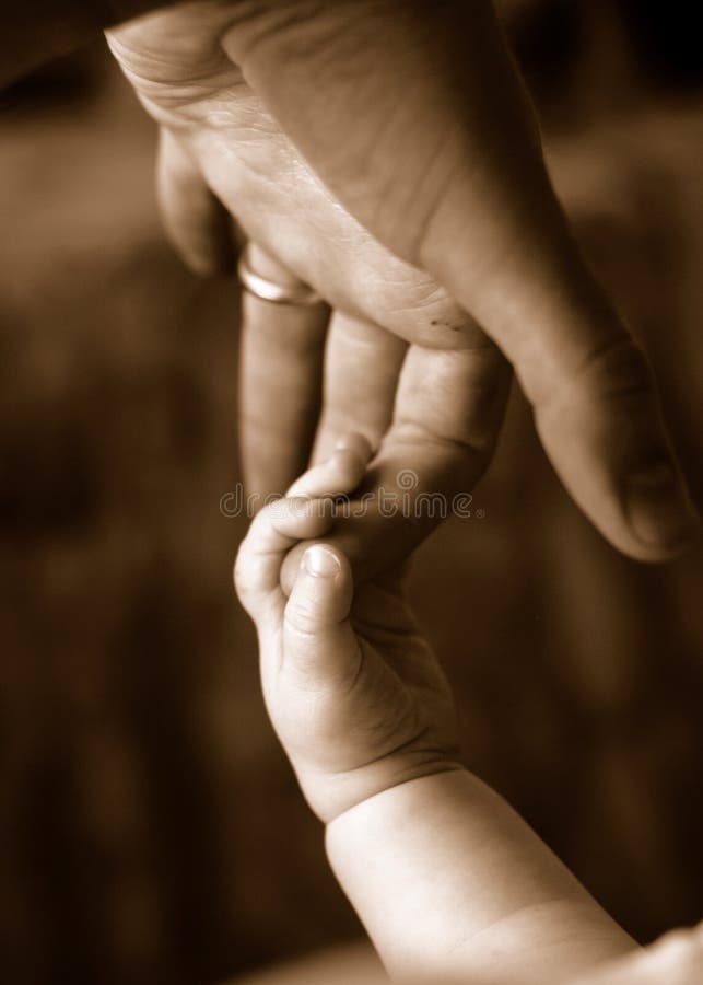 Sepia of baby holding father's finger. Sepia of baby holding father's finger