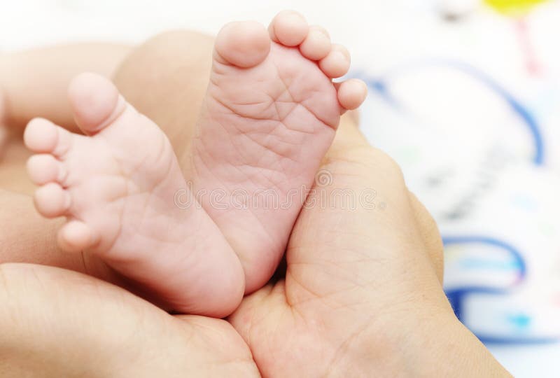 Schätzchenfüße in den Mutterhänden Neugeborener Kinderfuß lizenzfreies stockfoto Schätzchenfüße in den Mutterhänden Neugeborener Kinderfuß lizenzfreies stockfoto