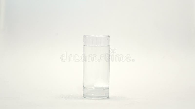 Schäumende weiße Tablette fällt in Glaswasser auf weißem Hintergrund Fizzy Tablette