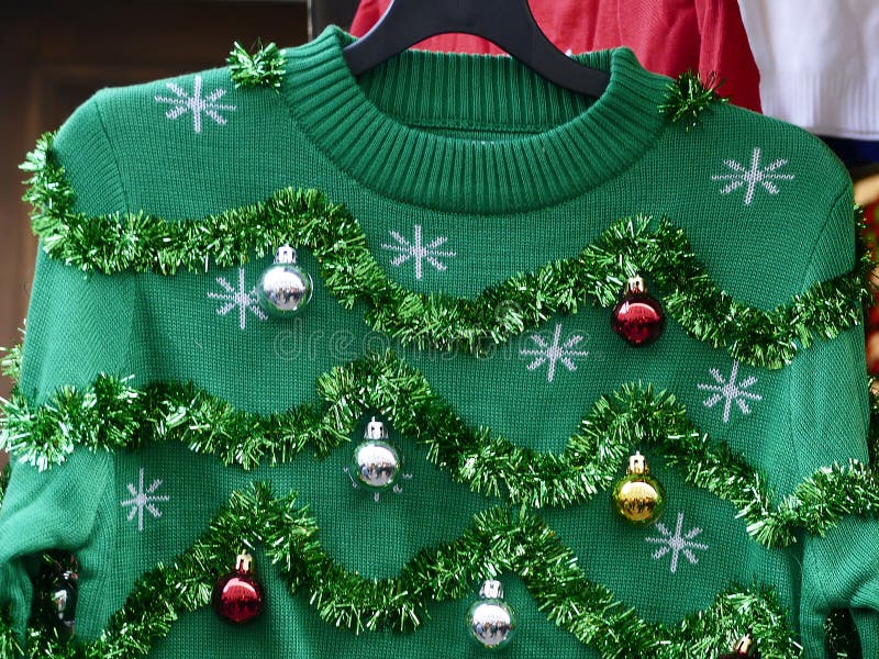 Schön oder hässlich: grüne Weihnachtsstrickjacke mit Dekorbällen