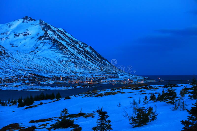 Beautiful view on Siglufjordur at dusk in winter. Siglufjordur is a small fishing town in a narrow fjord on the northern coast of Iceland. Beautiful view on Siglufjordur at dusk in winter. Siglufjordur is a small fishing town in a narrow fjord on the northern coast of Iceland.